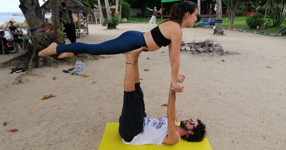 Young beautiful couple practicing acro yoga on the sea beach near water.  Man and woman doing everyday practice outdoor on nature background. Healthy  lifestyle concept. by Moon Soul. Photo stock - StudioNow